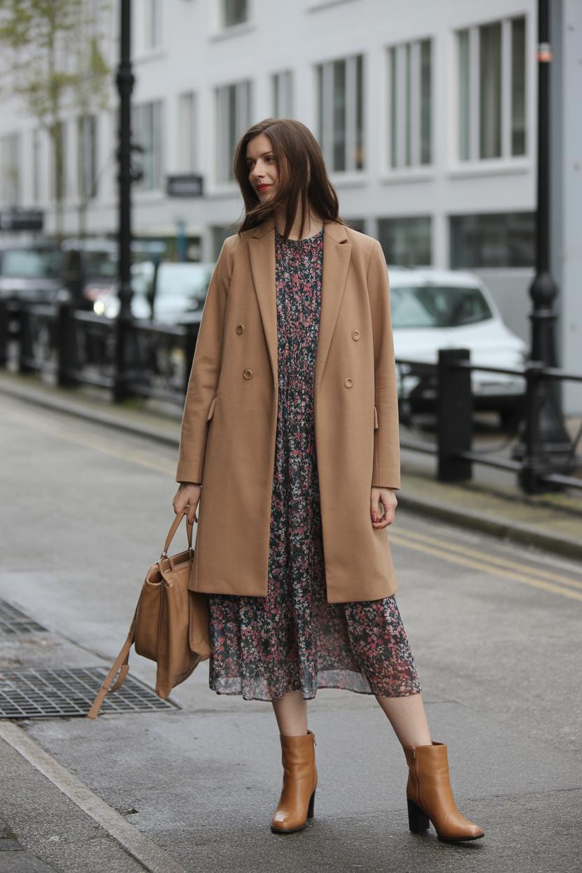 Layer a floral dress with a ‍camel wool coat and tan heeled boots